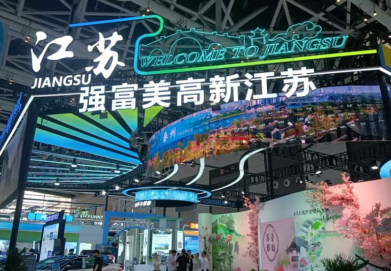 Jiangsu Province main entrance archway at 19th China Xi'an Silk Road International Exhibition Center featuring Welcome to Jiangsu signage with Taizhou city display and Laineng Technology booth visible inside exhibition hall