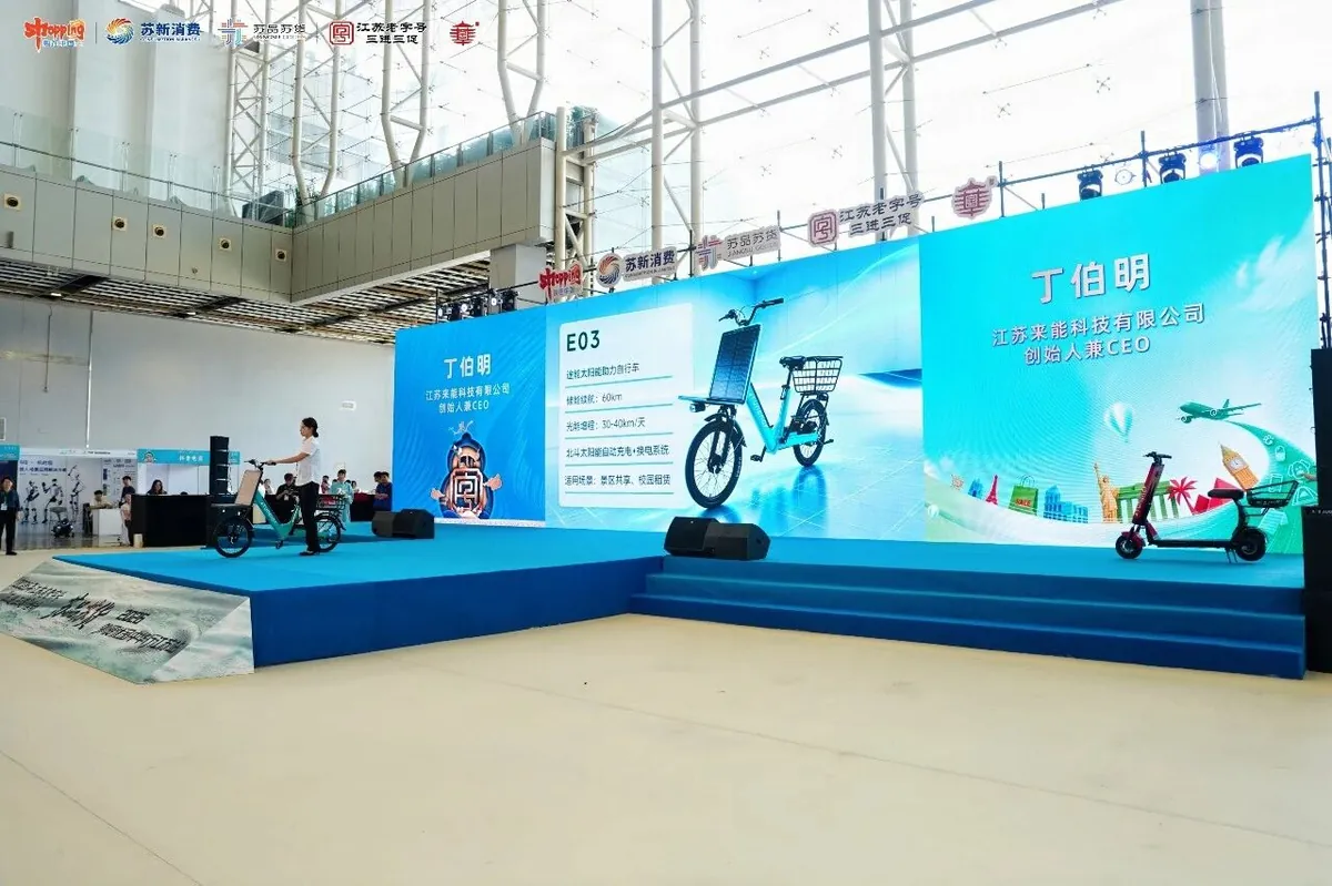 Wide stage shot of Laineng E03 and D02 solar vehicles on display at the 2026 Jiangsu expo